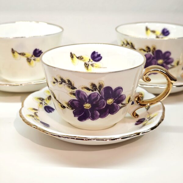 Coffee cup with crocuses and a golden handle.